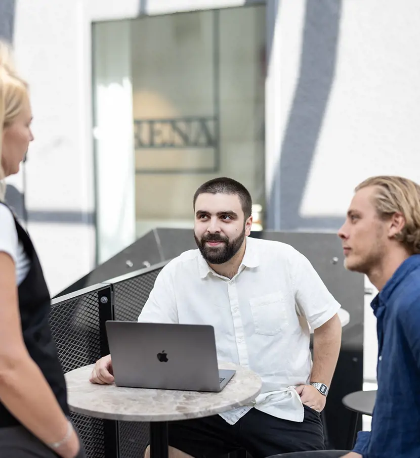 Utvecklare på webbyrå i Malmö bollar idéer vid en laptop.
